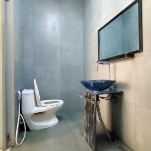 een badkamer met een wastafel en een toilet en een tv bij Family Room Gezonder Antapani in Bandung