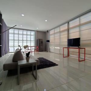 een woonkamer met een bank en een tv bij Family Room Gezonder Antapani in Bandung