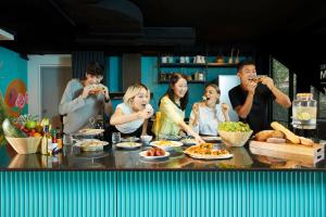 a group of people sitting around a table eating food at lyf Sukhumvit 8 Bangkok in Bangkok