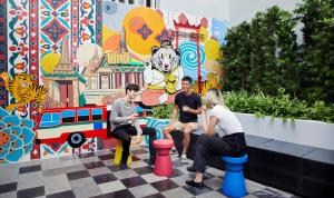 a group of people sitting in front of a mural at lyf Sukhumvit 8 Bangkok Managed by The Ascott Limited in Bangkok