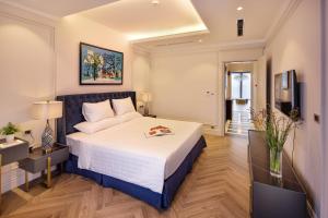 a bedroom with a large bed and a television at Apartments by Vitrine in Hanoi