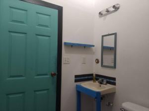 a bathroom with a blue door and a sink at Cozy Cabana1 in Roatán