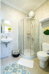 a bathroom with a shower and a toilet and a sink at Villa Siji Plemburan in Kejayan