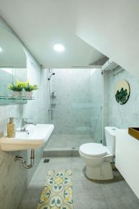a white bathroom with a sink and a toilet at Siji Plemburan Vacation Home in Kejayan