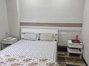 een slaapkamer met een bed en twee nachtkastjes bij Terrace Garden in Hyderabad