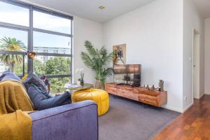 a living room with a couch and a large window at Deluxe Mahuhu 2 BR - Spark Arena - FREE PARKING in Auckland