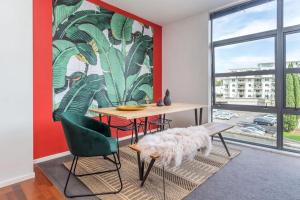 a dining room with a table and a green chair at Deluxe Mahuhu 2 BR - Spark Arena - FREE PARKING in Auckland