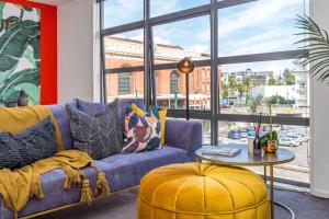 a living room with a blue couch and a table at Deluxe Mahuhu 2 BR - Spark Arena - FREE PARKING in Auckland