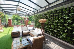 a patio with a green wall with chairs and a couch at Terrakotta Rishikesh in Rishīkesh