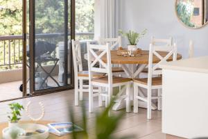 a white dining room with a table and chairs at Pinnacle 202 in Forster +9 photos