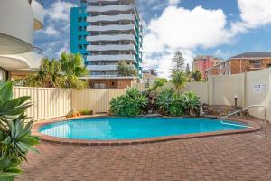 a swimming pool in a yard with a tall building at Pinnacle 202 in Forster