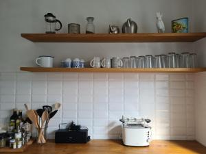 a kitchen with wooden shelves and a counter with utensils at Haus Sonnenlicht. Idylle am Ratzeburger See! in Ratzeburg