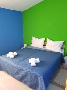 Apartments by the sea Vrsi - Mulo, Zadar - 18914 في فرسي: غرفة نوم بسرير ازرق بجدار اخضر