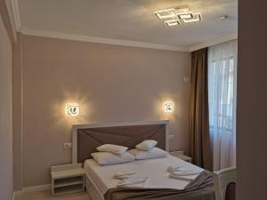 Un dormitorio con una cama con dos almohadas encima. en Onix Baile Herculane, en Băile Herculane