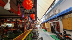 a restaurant with tables and chairs and red umbrellas at Vech Guesthouse Patong in Patong Beach