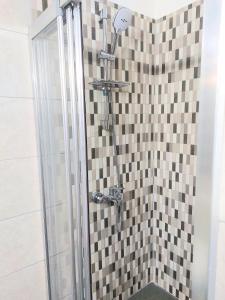 bagno con doccia e parete piastrellata di Secret Garden Guest House 02 a Famagusta
