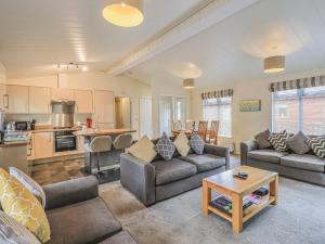 a living room with two couches and a kitchen at Daffodils Lodge in Bowness-on-Windermere