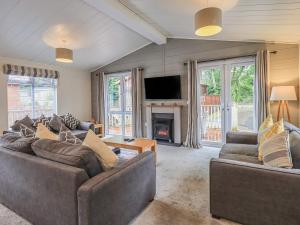a living room with two couches and a fireplace at Daffodils Lodge in Bowness-on-Windermere