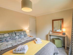a bedroom with a bed with towels on it at Daffodils Lodge in Bowness-on-Windermere