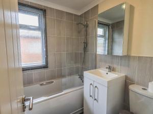 a bathroom with a sink and a tub and a toilet at Daffodils Lodge in Bowness-on-Windermere +27 photos