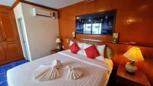 1 dormitorio con 1 cama con almohadas rojas y blancas en Vech Guesthouse Patong, en Patong Beach