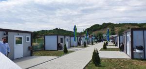 a man standing in front of a row of tiny houses at GLAMTAINER COURT in Curteni