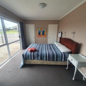 een slaapkamer met een bed, een tafel en een raam bij The Retreat Taupo in Taupo