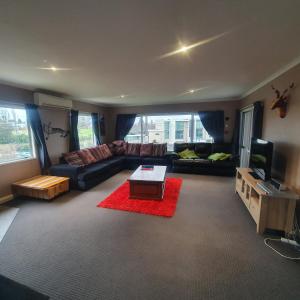 un soggiorno con divano e tavolo di The Retreat Taupo a Taupo