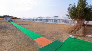 una línea verde y naranja en un campo con tiendas de campaña en Kutch Classic Resort Camp, en Dhordo