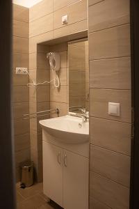 uma casa de banho com um lavatório e um espelho em SárvárLAK Apartmanház em Sárvár