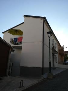 ein weißes Gebäude mit einem Schirm auf der Seite in der Unterkunft Apartments by the sea Gradac, Makarska - 18877 in Gradac