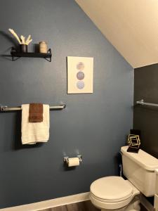 a bathroom with a toilet and towels on a wall at Suede in Salem