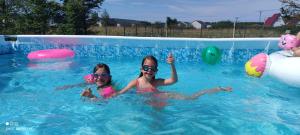two girls are in a swimming pool at Urlopownia domki w Gąskach, gorąca bania, basen, duży teren in Gąski