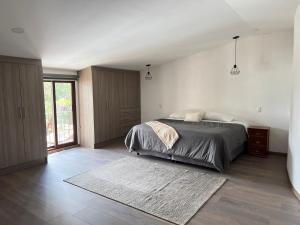 a bedroom with a large bed and a rug at Loft Santiago Val’quirico in Tlaxcala de Xicohténcatl