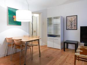 comedor con mesa, sillas y TV en Sanders Park - One-Bedroom Apartment Near a Huge City Park en Copenhague