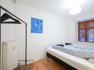 a white bedroom with a bed and a window at Sanders Park - One-Bedroom Apartment Near a Huge City Park in Copenhagen