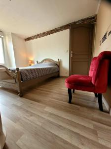 a bedroom with a bed and a red chair at Au 1894 Grand Cru in Avize