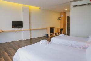a room with two beds and a flat screen tv at Roxy Hotel Serian in Serian