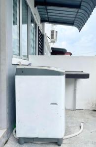 an old refrigerator sitting outside of a building at RS HOMESTAY BANDAR SERI ISKANDAR in Seri Iskandar