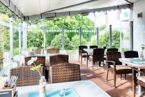 um restaurante com mesas, cadeiras e janelas em Select Hotel A1 Bremen-Stuhr em Stuhr
