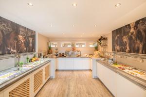 a large kitchen with white counters and paintings on the walls at Select Hotel A1 Bremen-Stuhr in Stuhr