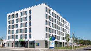 ein weißes Gebäude an der Ecke einer Straße in der Unterkunft Holiday Inn Express - Krefeld - Dusseldorf, an IHG Hotel in Krefeld