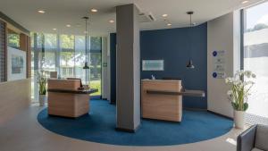 an office with a reception area with blue walls at Holiday Inn Express - Krefeld - Dusseldorf by IHG in Krefeld