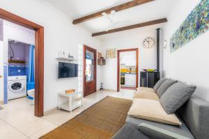 a living room with a couch and a tv at Es Cantonet in Porto Cristo
