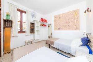 a bedroom with two beds and a painting on the wall at Es Cantonet in Porto Cristo