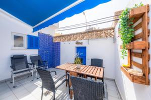 a patio with a wooden table and chairs at Es Cantonet in Porto Cristo