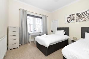 Postel nebo postele na pokoji v ubytování JOIVY Rose Street Modern Flat