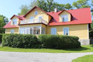 una casa amarilla con techo rojo en Nurmeveski Guesthouse, en Nurme