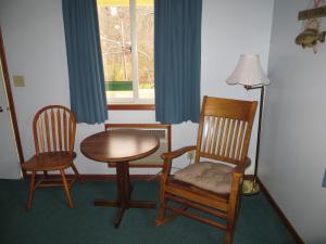 a room with two chairs and a table and a lamp at Green Valley Motor Lodge in Nashville