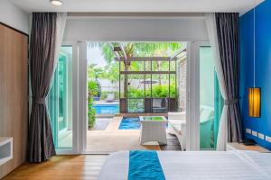 a bedroom with a bed and a view of a pool at Hotel COCO Phuket Bangtao - SHA Extra Plus in Bang Tao Beach